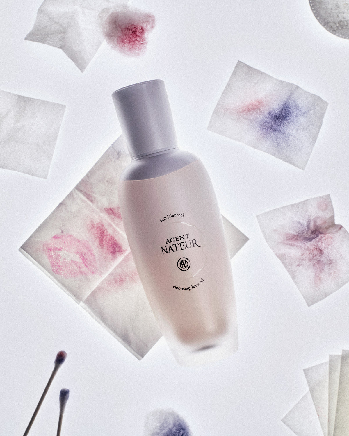 Holi (Cleanse) - Agent Nateur - flacon parmi des cotons démaquillants tachés de maquillage