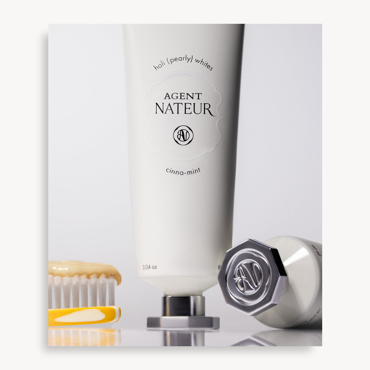 Holi (Pearly) Whites Probiotic Whitening Toothpaste - Agent Nateur - tube styled with a toothbrush
