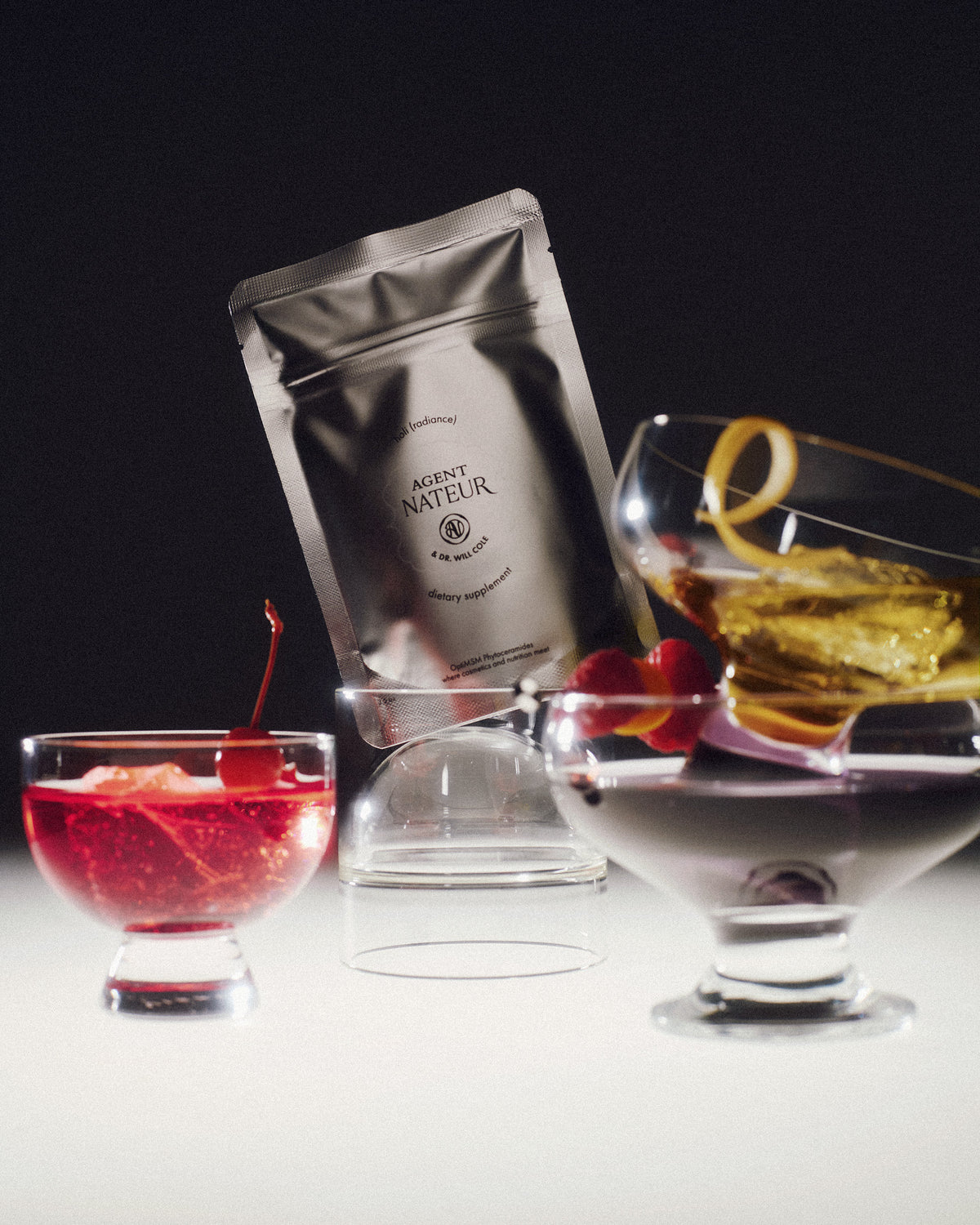 Duo Holi (Mane) + Holi (Radiance) - Agent Nateur - sachet Holi (Radiance) parmi des verres de cocktail
